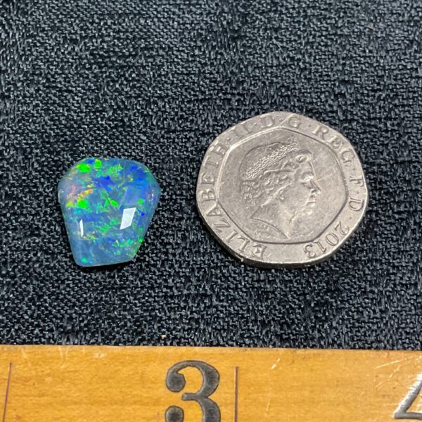 Vibrant coffin-shaped opal cabochon gemstone with colourful play-of-colour.