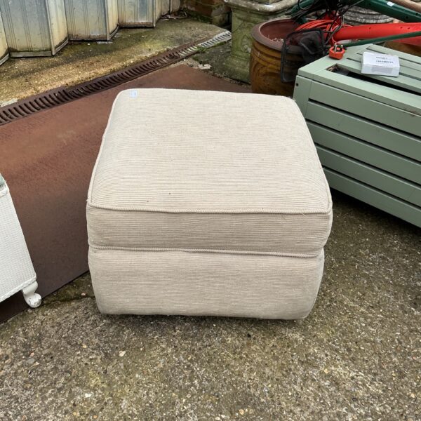 Vintage padded footstool for comfortable home seating.