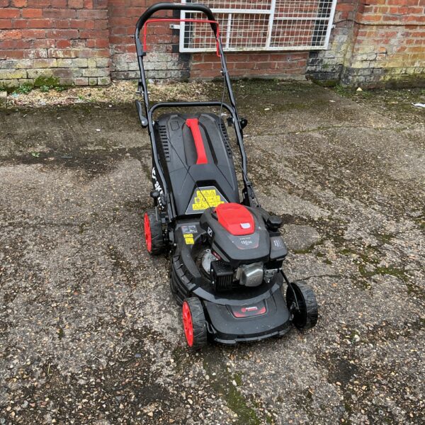 Front view of a used Parker petrol lawnmower in a garden setting.
