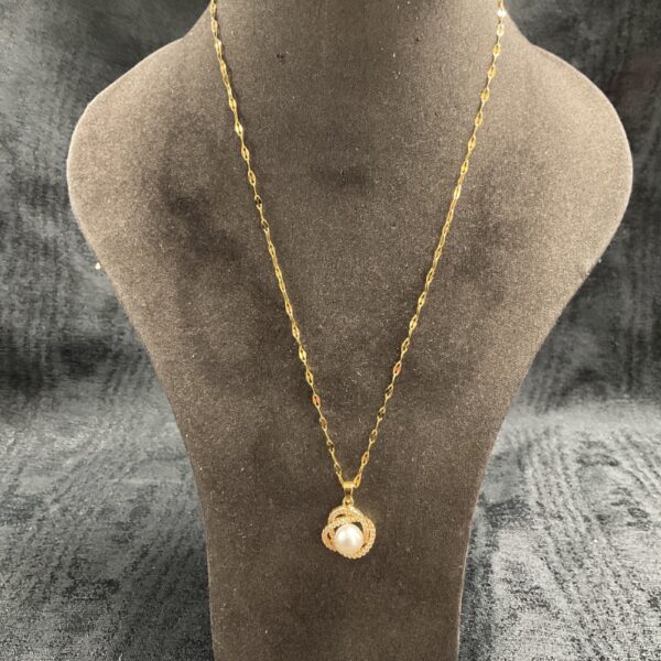Elegant gold-plated pearl pendant necklace on display.