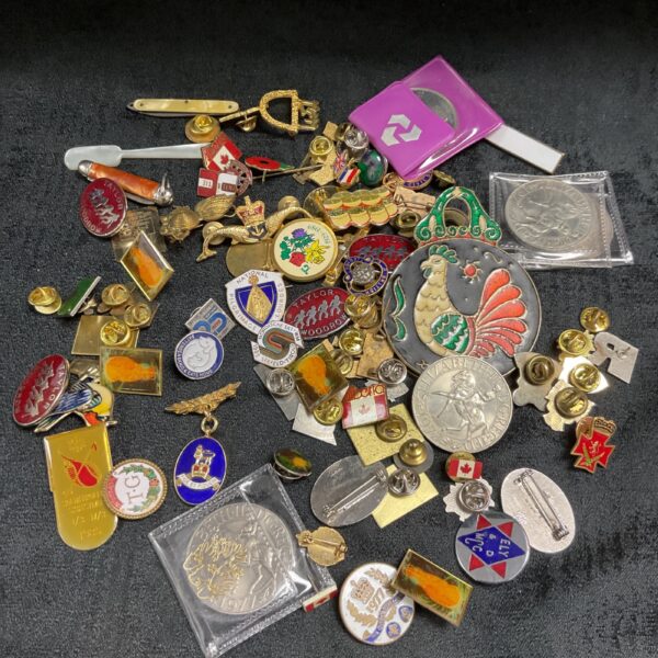 Mixed lot of vintage pin badges, coins, and pocket knives.