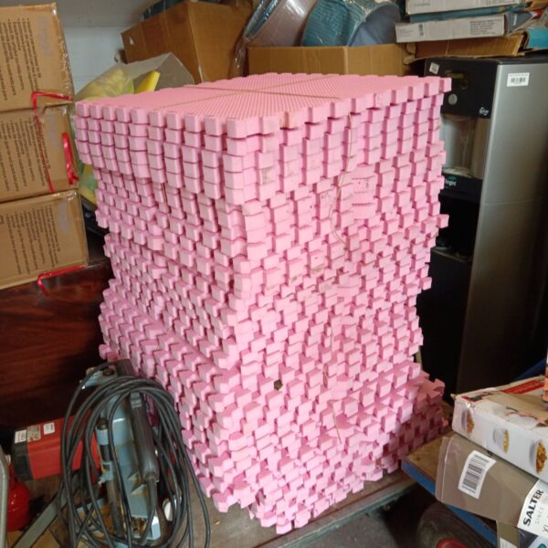 Large lot of pink foam fitness mats for gym or exercise.