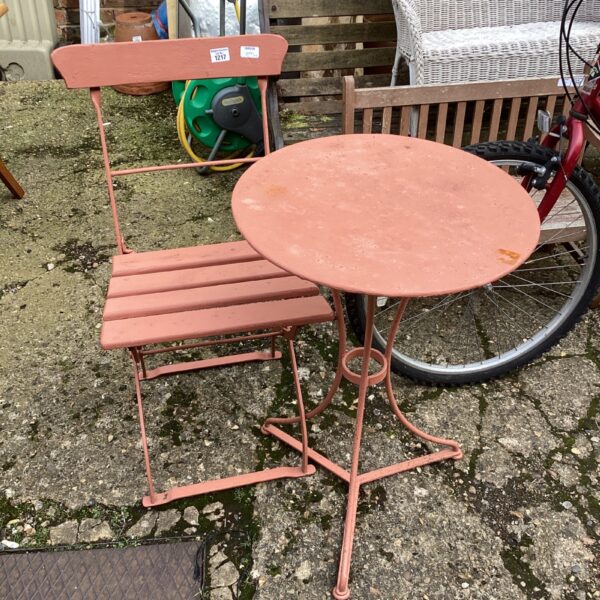 Vibrant pink vintage garden furniture set with folding chair and table.