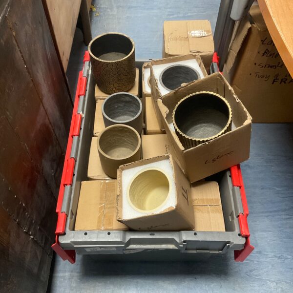 Assorted terracotta and ceramic plant pots in a garden lot.