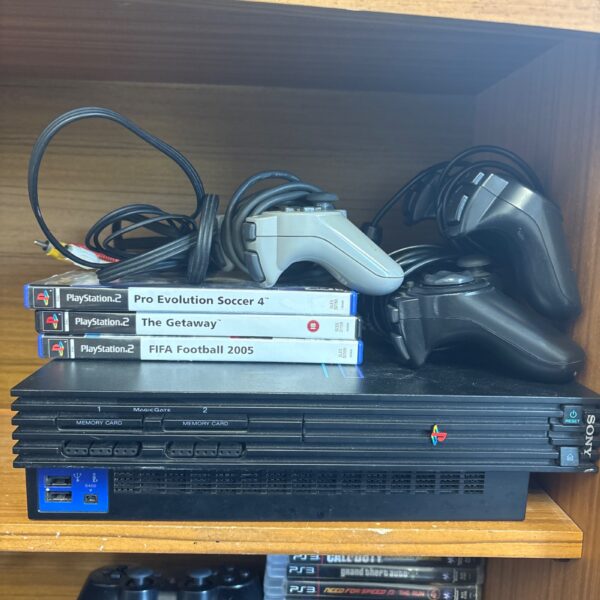 Sony PlayStation 2 console with controllers and games for retro gaming.