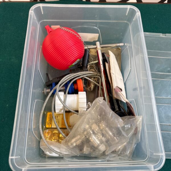 Assorted plumbing parts and fittings in a plastic tray.