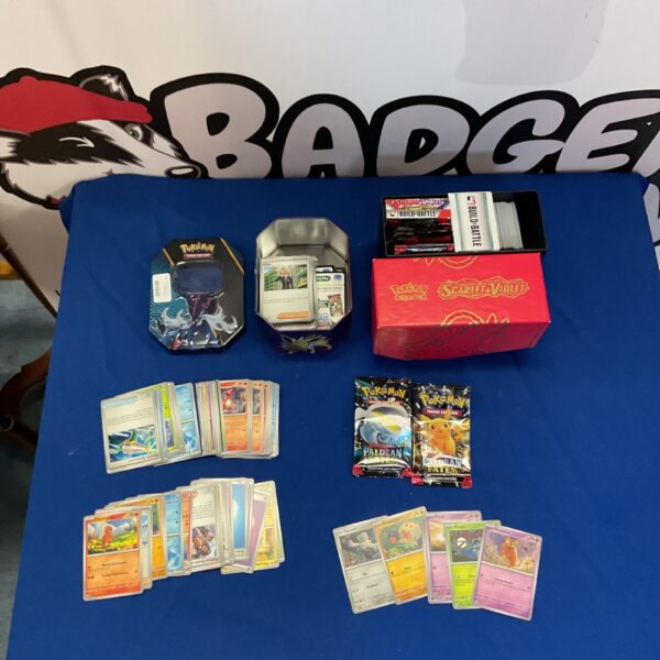 Pokemon card tin and box lot with opened packets.