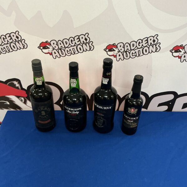 Collection of four port wine bottles including Cockburns.