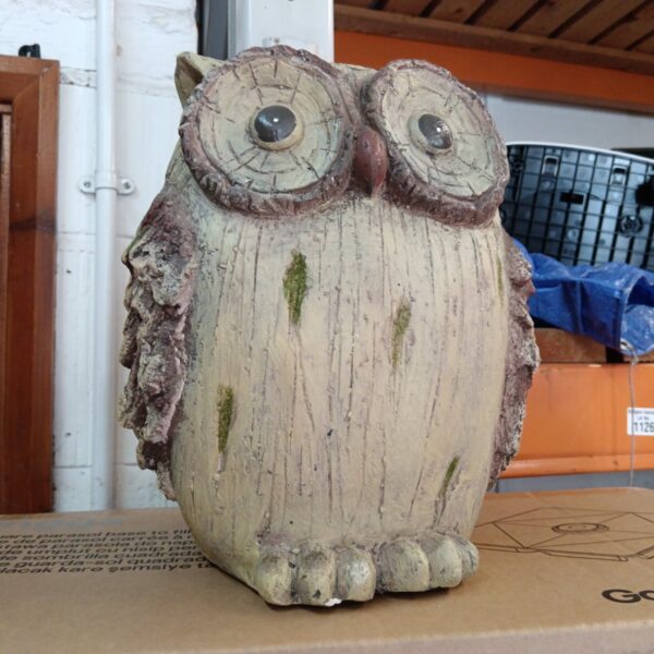 Detailed pottery owl garden ornament with moss growth.