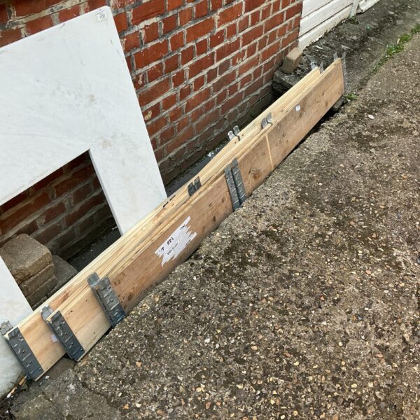 Two wooden raised garden bed frames in an outdoor setting.
