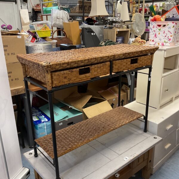 Vintage rattan console table with dark metal frame and two drawers.