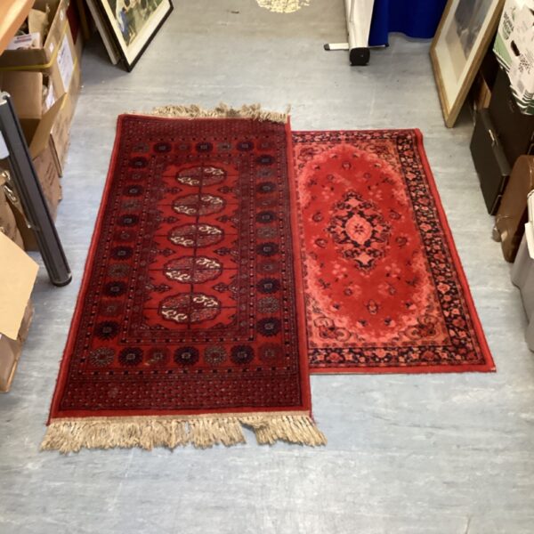 Two red runner rugs displayed in a hallway setting.