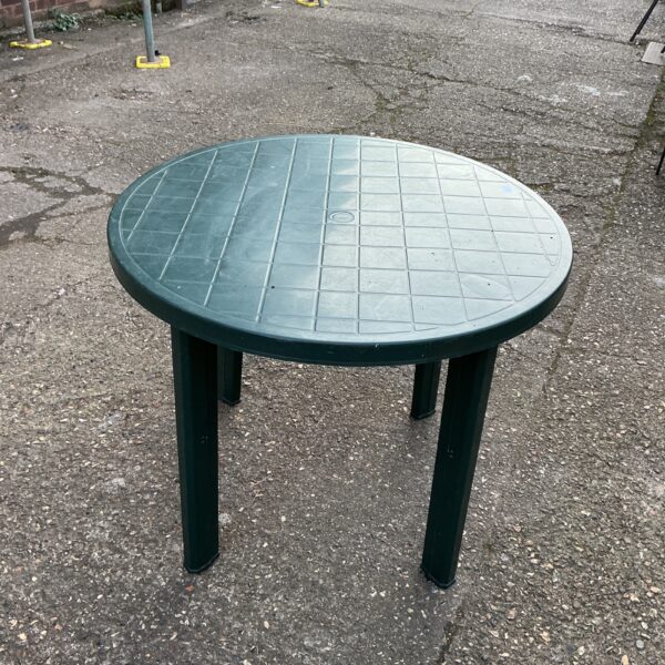 Round plastic garden table in an outdoor setting.