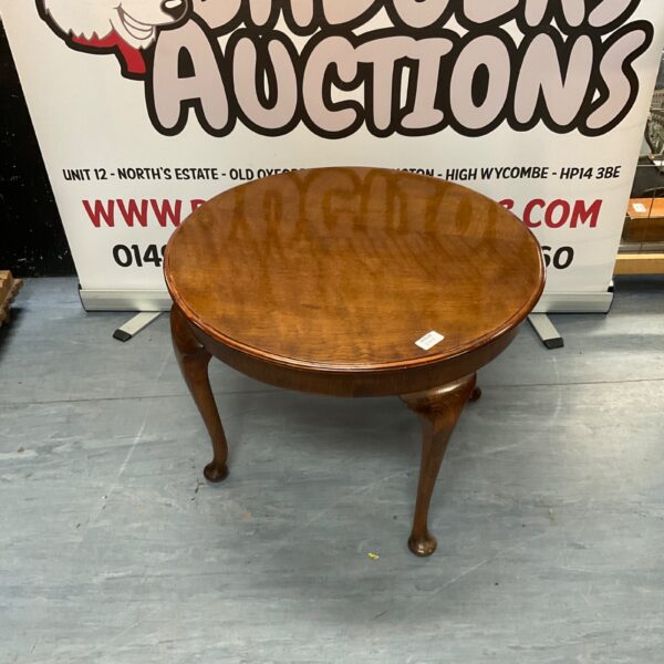 Vintage round wooden coffee table with curved legs.