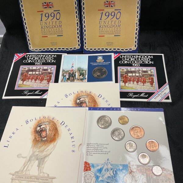 Seven Royal Mint UK coin collection sets in original packaging.