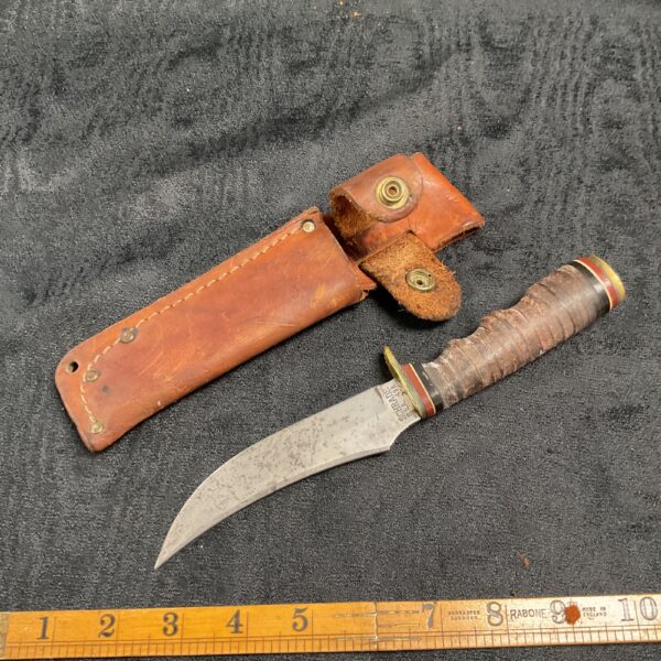 Vintage Schrade knife with leather sheath, classic fixed blade.