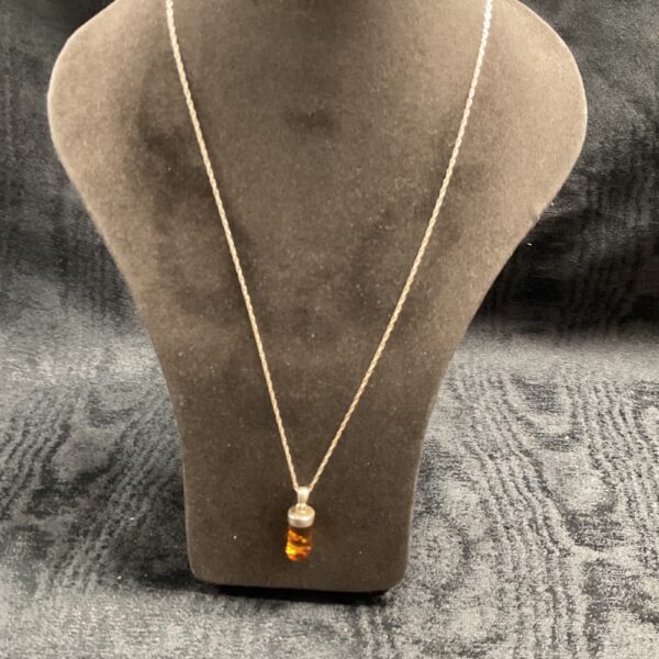 Silver amber pendant necklace on a delicate chain.