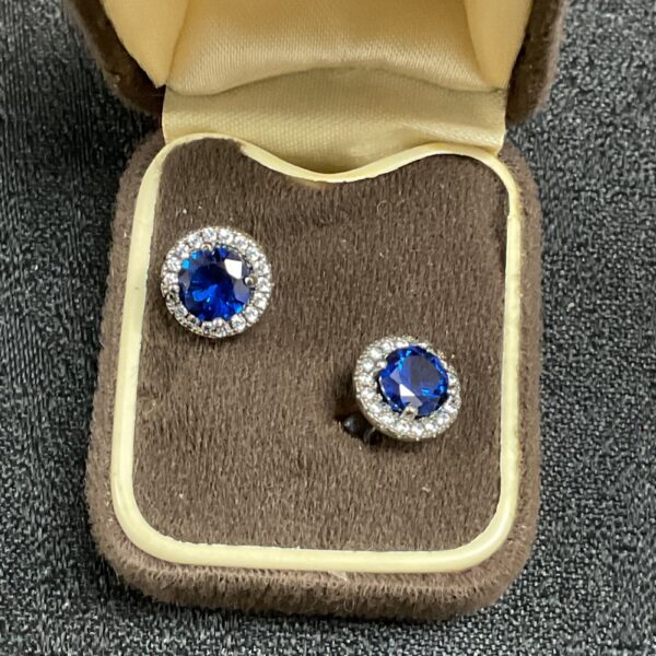 Silver blue cluster stud earrings on display.