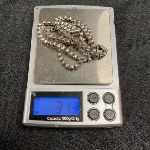 Close-up of a lot of broken silver necklaces for repair.