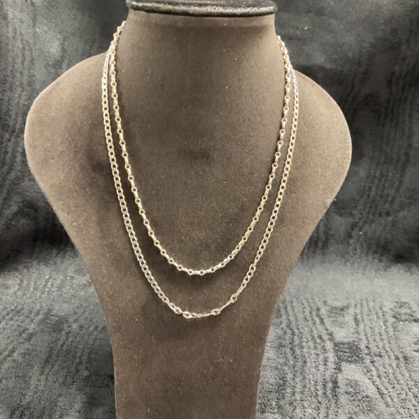 Two delicate 925 silver chain necklaces on a display bust.