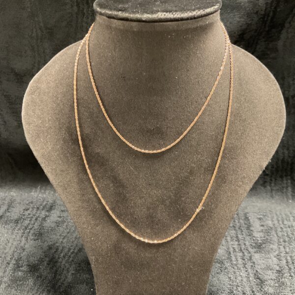 Delicate silver gilt chain necklace on display.