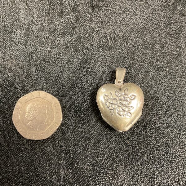 Vintage silver heart locket with clover detail.