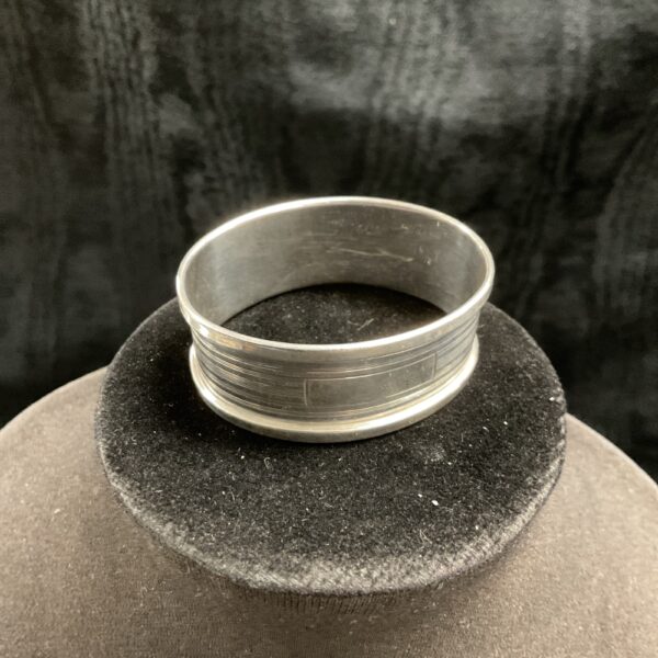 Vintage silver napkin ring on black velvet.