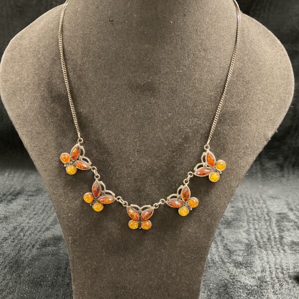 Close-up of 925 silver opal butterfly necklace on a display.
