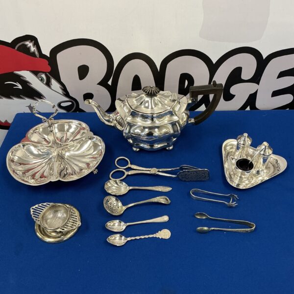 Vintage silver plate teapot and cruet set on display.