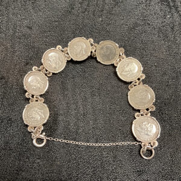Close-up of a silver threepence coin bracelet with George V coins.