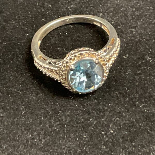 Close-up of a 925 silver ring with a blue topaz gemstone.