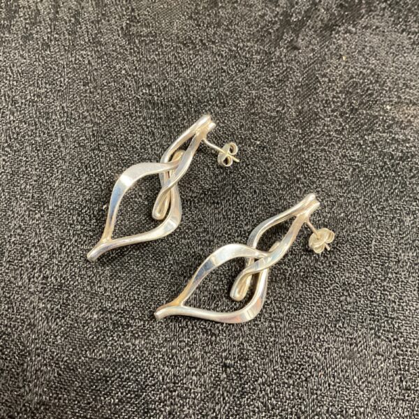Close-up of silver wishbone stud earrings on a white background.