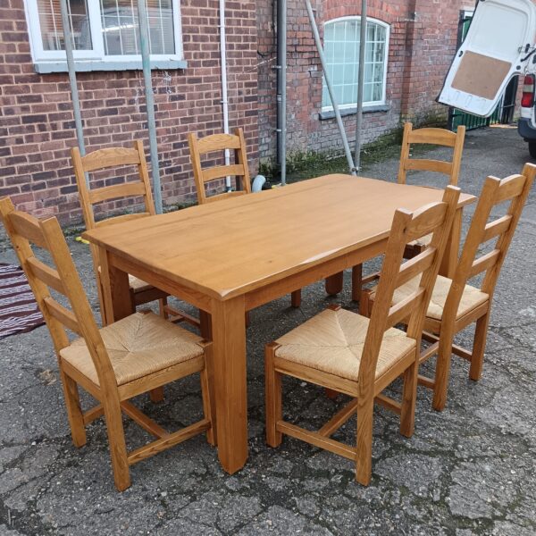 Solid oak dining table and six chairs in a farmhouse setting.