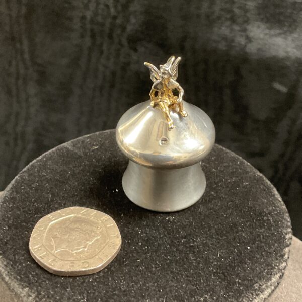 Hallmarked sterling silver tooth pot with a gilded fairy figure.