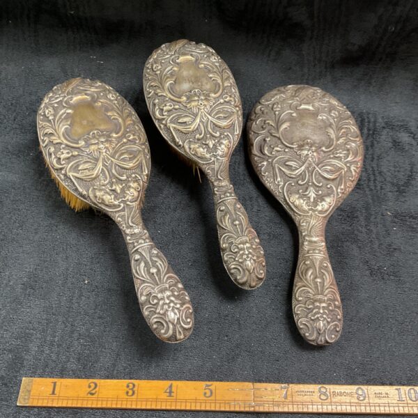 Antique Stirling silver dressing table set with brushes and mirror.