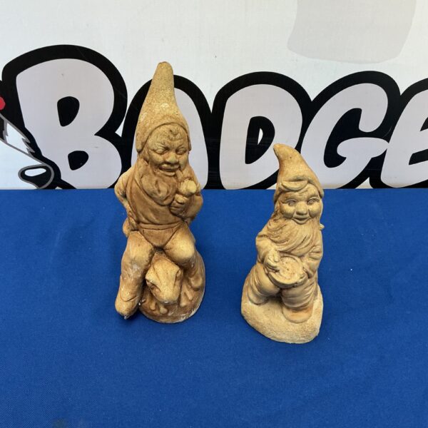 Pair of vintage stone garden gnomes for outdoor decoration.
