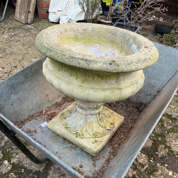 Weathered stone garden planter displayed on a garden trolley.