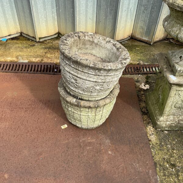 Pair of weathered stone effect garden planters for outdoor use.