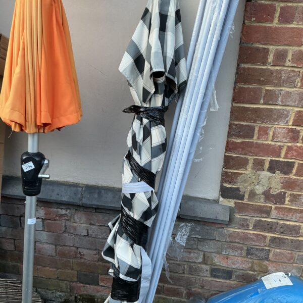 Large striped patio parasol in a garden setting.