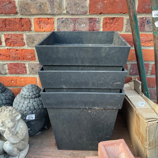 Three large dark square plant pots for garden use.