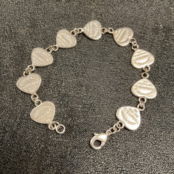 Silver Tiffany heart bracelet with interconnected links.