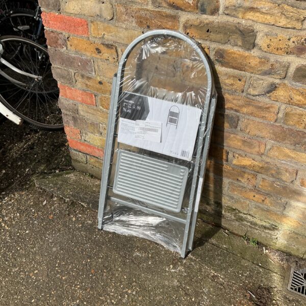 Aluminium two-step ladder, folded and ready for use.