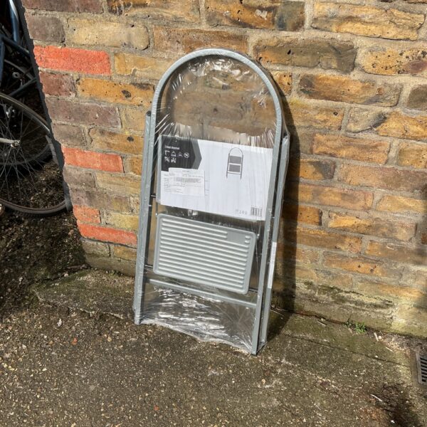 Metal two-step ladder for household use, folded for storage.