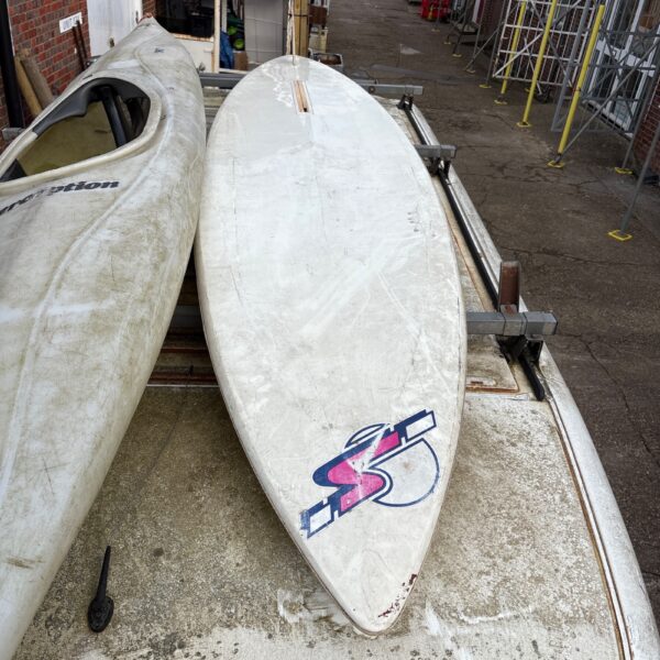 Used windsurfing board for sale, showing wear and tear.