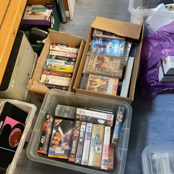 Stack of boxes filled with vintage VHS movie cassettes.