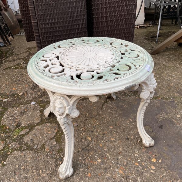 Intricate Victorian style cast iron garden table for outdoor use.