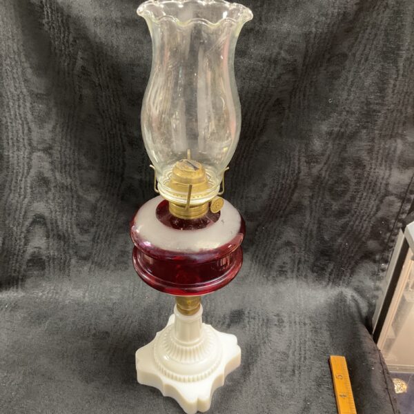Antique Victorian cranberry oil lamp with milk glass base.