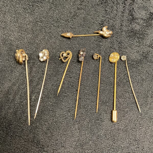 Antique Victorian hat pin collection with decorative glass and metal tops.