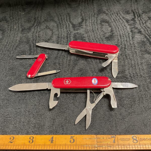 Red handled Victorinox Swiss Army Knife in a lot of three.