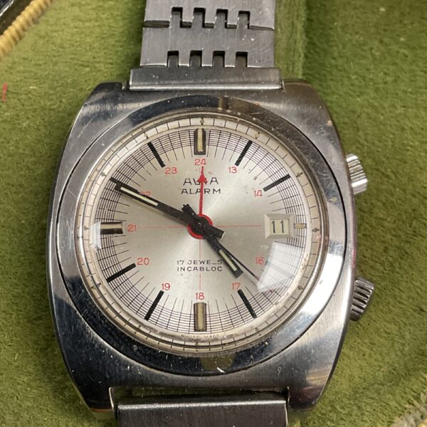 Close-up of vintage Avia alarm wristwatch with silver dial.